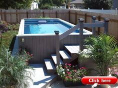 an above ground swimming pool surrounded by plants and flowers with stairs leading up to it