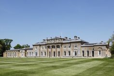 a large brown building sitting on top of a lush green field