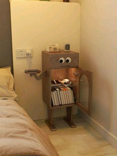 a bed room with a neatly made bed and a small cabinet in the corner that has eyes on it