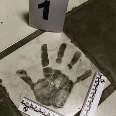 a handprint on the ground next to a ruler