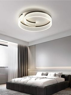 a bedroom with a large bed in the middle and a round ceiling light above it