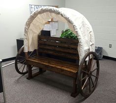 a wooden bench sitting under a white tent