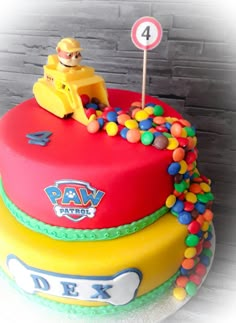 a birthday cake with the number four on it and a toy car in the middle