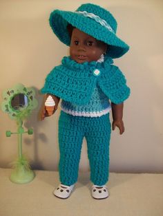 the doll is wearing a blue crocheted outfit and hat