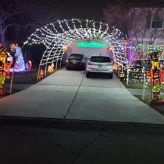 cars parked in front of a house covered with christmas lights and decorations on the driveway