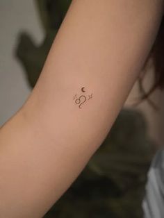 a woman's arm with a small tattoo on the left side of her arm