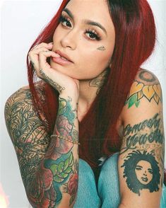 a woman with red hair and tattoos on her arms