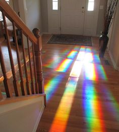 the sun is shining through the stained glass on the floor in front of the door