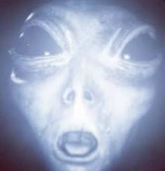 an alien face is shown in the dark