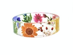 This is a stunning bangle, filled with beautiful real flowers - orange daisy, blue cornflower, yellow buttercup, surrounded by rich green fern leaves, and gorgeous white and orange baby's breath flowers. It is a chunky bangle with a straight profile - the same thickness around the entire circumference of the piece. Available sizes: Size XS Inside diameter 2 9/32" (58mm) wide 3/4" (18mm) thick 1/8" (4mm) Size S: Inside diameter 2 23/34" (60mm) wide 4/8" (15mm) thick 9/16" (6mm) Size M: Inside dia Adjustable Flower Bracelets With Pressed Flowers, Multicolor Flower Jewelry With Pressed Flowers, Multicolor Flower Shaped Jewelry With Pressed Flowers, Orange Flower Bracelet For Gift, Orange Baby, Resin Bangles, Resin Bracelet, Eco Resin, Rainbow Bracelet