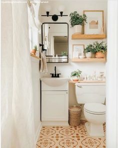 a bathroom with a toilet, sink and mirror on the wall next to a shower curtain