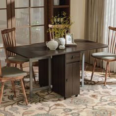 a dining room table with two chairs and a potted plant on top of it