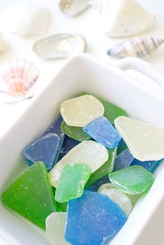 sea glass pieces in a white bowl on a table