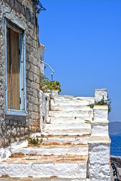 an old building with stone steps leading to the ocean