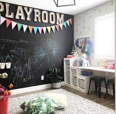 a playroom with chalkboard and toys on the wall