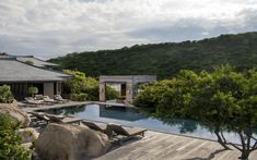 an outdoor swimming pool surrounded by trees and rocks