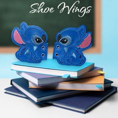 there is a pair of shoes that are on top of books with the words shoe wings