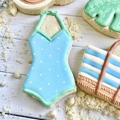 decorated cookies are sitting on a table with sand and beach items in the foreground