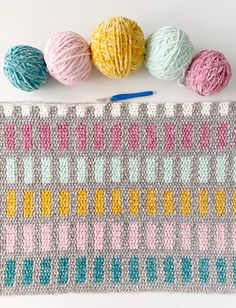 three balls of yarn sitting on top of a table next to some crochet