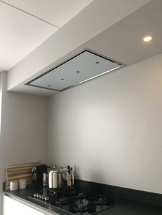 a stove top oven sitting inside of a kitchen next to a counter with pots and pans on it