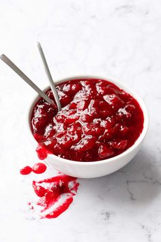 a white bowl filled with cranberry sauce on top of a marble countertop