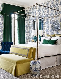 a bedroom with blue and white wallpaper, green drapes, yellow bedding, and a canopy bed