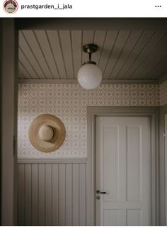 a hat is hanging on the wall next to a door with a light above it