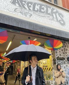 a man holding an umbrella in front of a store