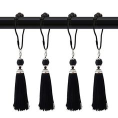 four black tassels hanging from a metal bar