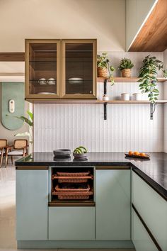 a kitchen with green cabinets and black counter tops