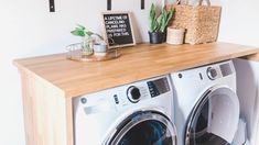 a washer and dryer sitting next to each other on a wooden counter top