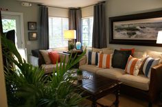 a living room filled with furniture and lots of pillows on top of it's couches