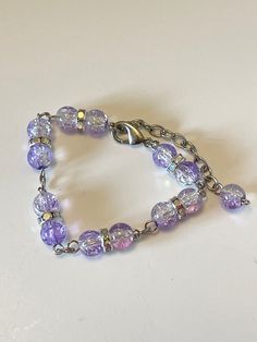 Beautiful handmade bracelet with purple and clear crackle glass beads. Measures 7" long, 1.75" extension with lobster claw closure. Comes in a gift box. Adjustable Purple Metal Beaded Bracelets, Purple Beaded Crystal Bracelet For Jewelry Making, Lavender Adjustable Beaded Crystal Bracelet, Purple Beaded Bracelets With Czech Glass, Adjustable Purple Beaded Crystal Bracelet, Purple Crystal Beaded Bracelets As Gift, Purple Crystal Bracelets With Round Beads, Adjustable Purple Crystal Jewelry, Purple Crystal Bracelets As Gift