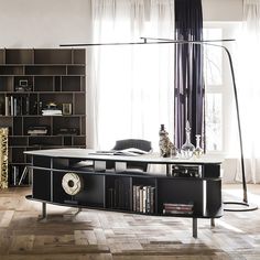 a living room filled with furniture and a book shelf in front of a large window