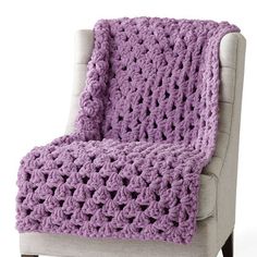 a purple crocheted blanket sitting on top of a chair