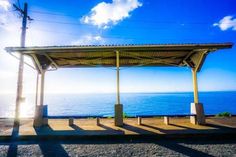 the sun shines on an empty gazebo by the ocean