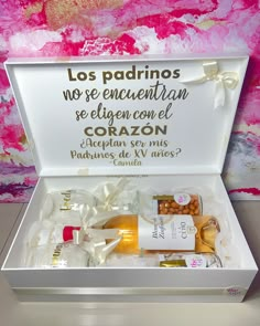 an open white box containing various items in front of a pink and yellow wall with writing on it