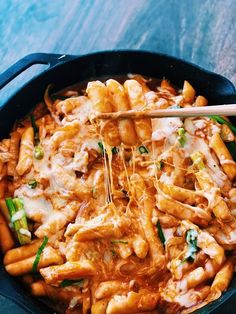 a skillet filled with pasta covered in sauce and cheese