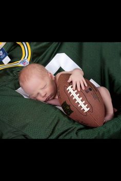 a baby sleeping on top of a football