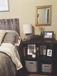 a bed room with a neatly made bed and two baskets on the nightstands next to it