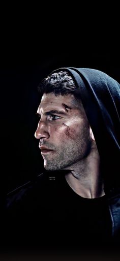 a man wearing a black hoodie looking off into the distance with his eyes closed