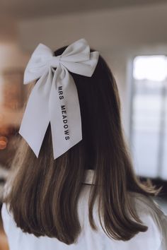 a woman with long hair wearing a white bow