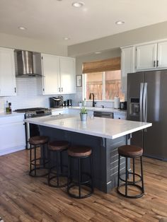 a kitchen with an island and three stools