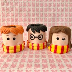 three harry potter mugs sitting next to each other on a pink and white background