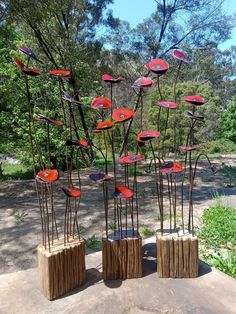 some very pretty metal art pieces in the middle of a field with trees and grass