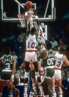 a group of men playing basketball against each other