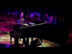 a man sitting at a piano on top of a stage