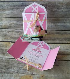 an open pink and white box with a horse on it's side, sitting on top of a wooden table