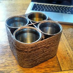 four metal cups sitting on top of a wooden table