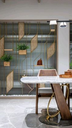 a dining room with a marble table and chairs in front of a glass wall that has plants on it